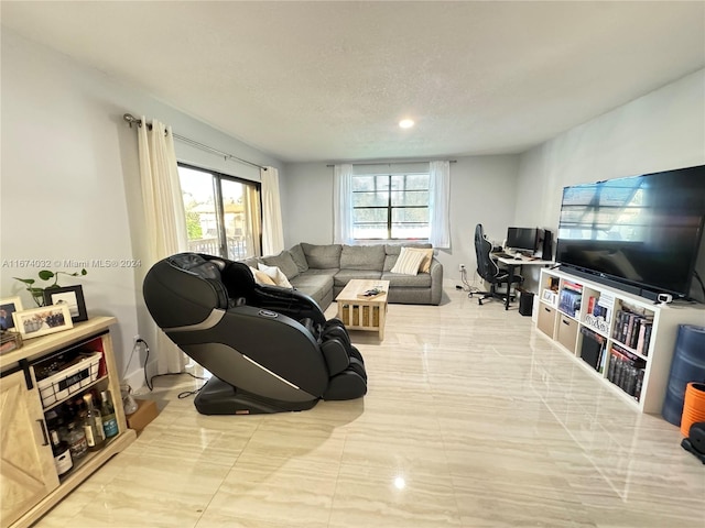 living room featuring a textured ceiling and a healthy amount of sunlight