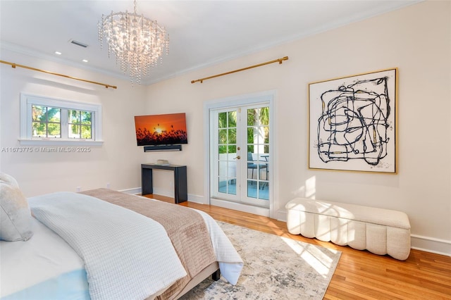 bedroom with french doors, crown molding, hardwood / wood-style floors, a chandelier, and access to outside