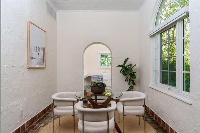 dining area featuring ornamental molding and a healthy amount of sunlight