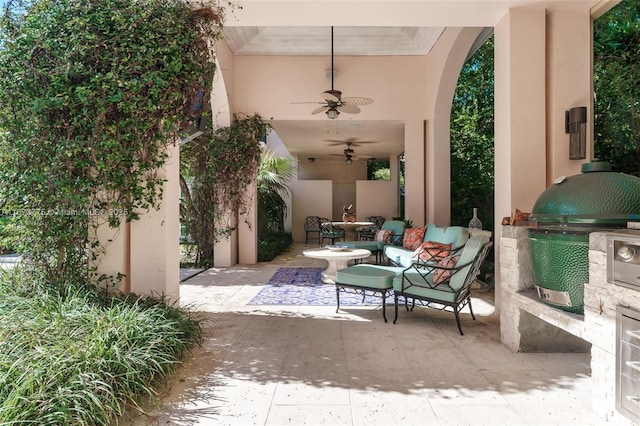 view of patio / terrace featuring ceiling fan, area for grilling, and exterior kitchen