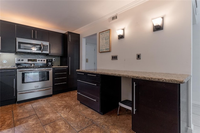 18071 Biscayne Blvd Unit 303, Aventura, FL 33160 - kitchen featuring crown molding, appliances with stainless steel finishes, dark cabinetry, backsplash, and visible vents