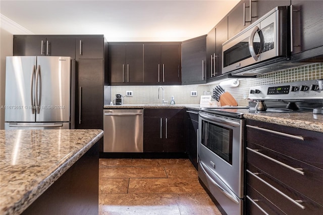 kitchen with appliances with stainless steel finishes, dark brown cabinets, light stone counters, and sink