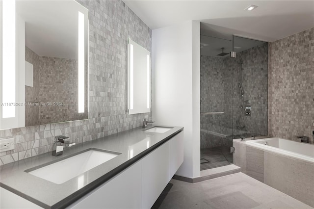 bathroom with tile walls, vanity, and plus walk in shower