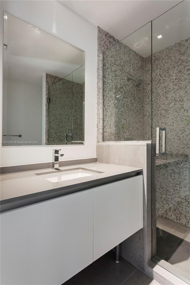 bathroom featuring vanity, an enclosed shower, and tile patterned floors