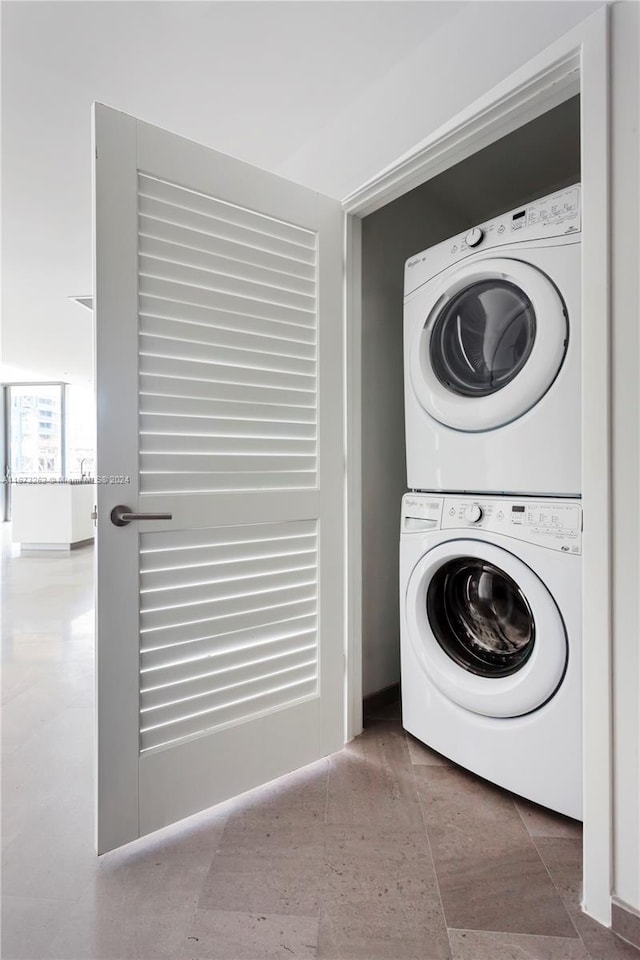 laundry room with tile patterned floors and stacked washer / drying machine