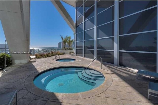 view of pool featuring a patio and a community hot tub