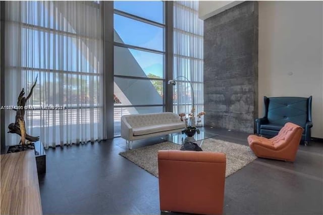 living room with a high ceiling and floor to ceiling windows