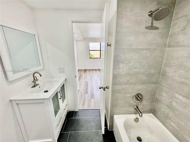 bathroom featuring tiled shower / bath combo and vanity