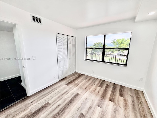 unfurnished bedroom with light hardwood / wood-style floors and a closet