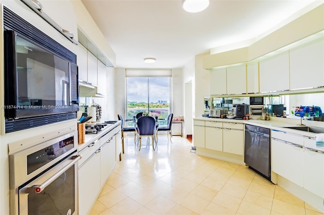 kitchen featuring sink, white cabinetry, and black appliances