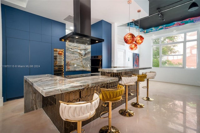 kitchen with blue cabinetry, a breakfast bar area, black appliances, and island range hood