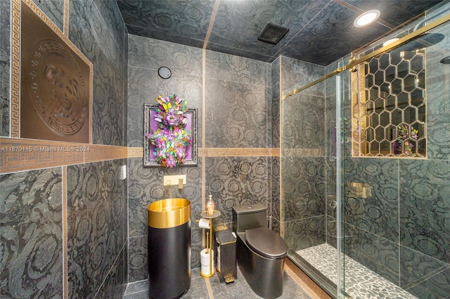 bathroom featuring an enclosed shower, tile walls, and toilet