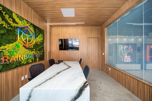 interior space featuring wood walls, wooden ceiling, and concrete flooring