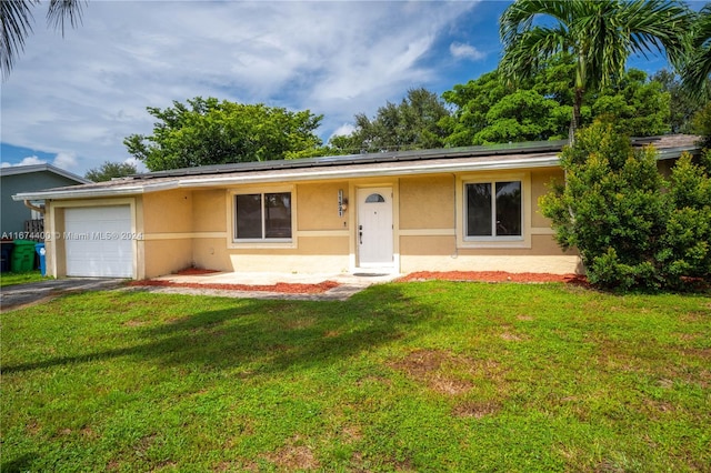 single story home with a garage and a front lawn