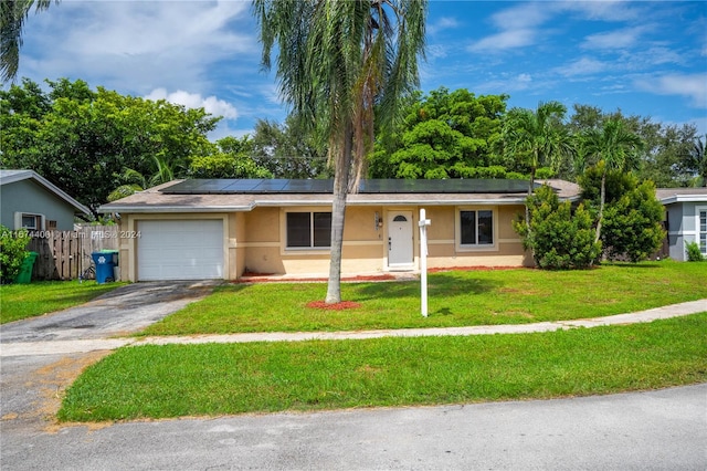 single story home with a garage, a front lawn, and solar panels