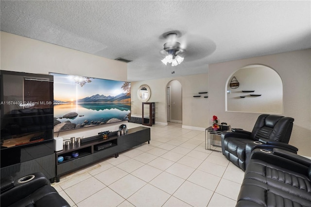 living room featuring ceiling fan, a textured ceiling, and light tile patterned floors