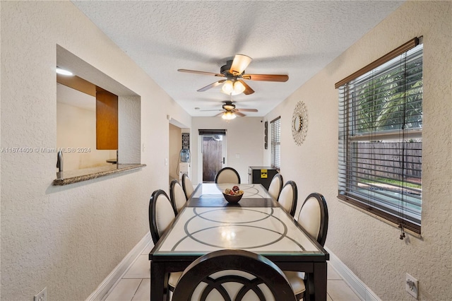 dining space featuring ceiling fan, a textured ceiling, and light tile patterned flooring