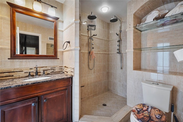 bathroom featuring vanity, tiled shower, and toilet