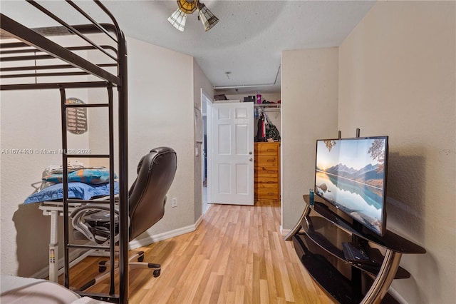 office space with a textured ceiling, ceiling fan, and light hardwood / wood-style flooring