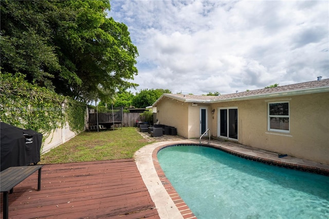 view of pool featuring a yard and a wooden deck