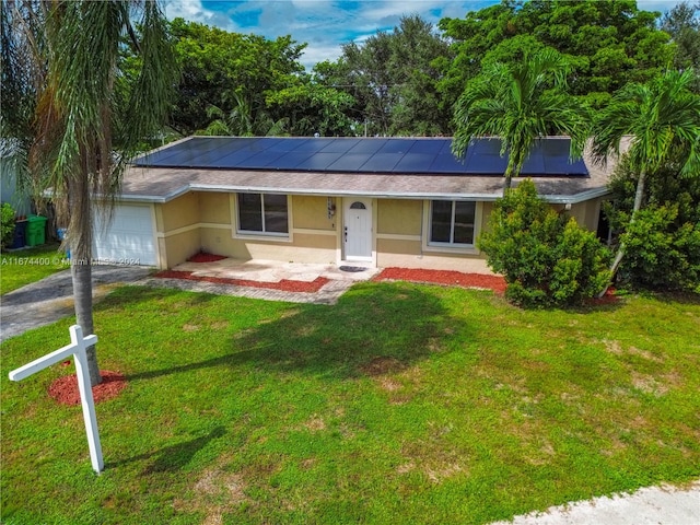 ranch-style home with a garage, a front yard, and solar panels