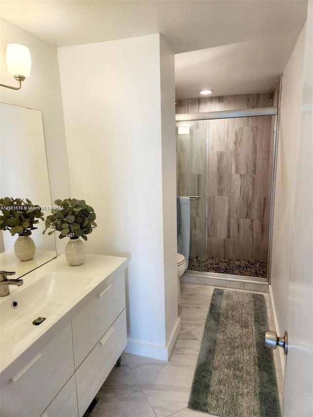 bathroom featuring toilet, walk in shower, and vanity