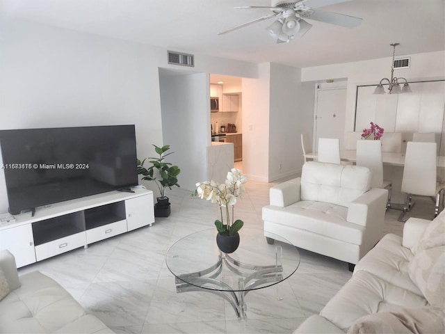 living room with ceiling fan with notable chandelier