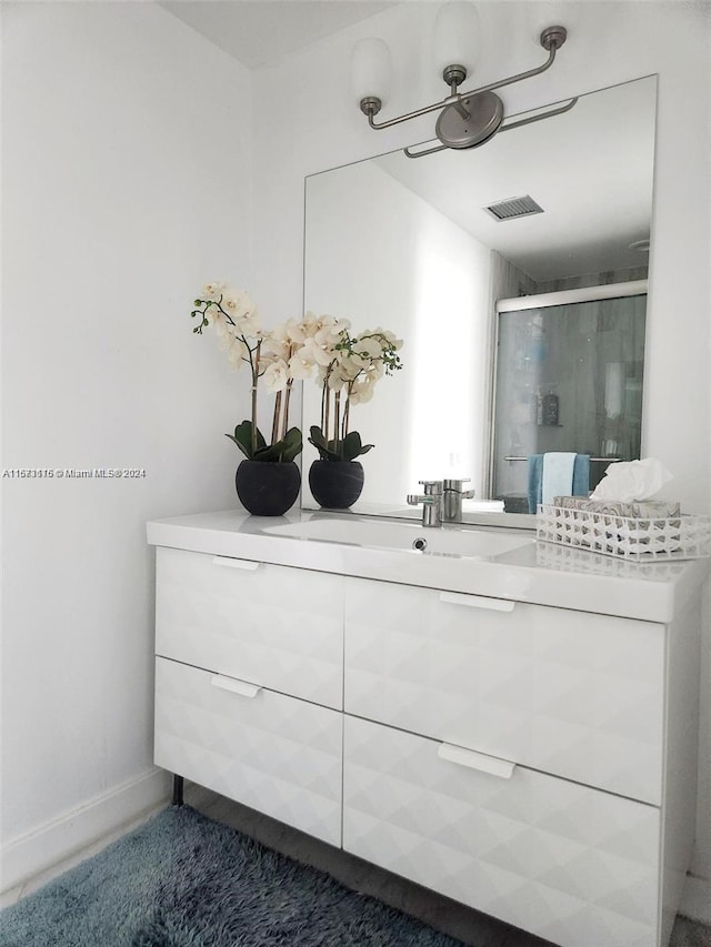 bathroom with vanity and a shower with shower door