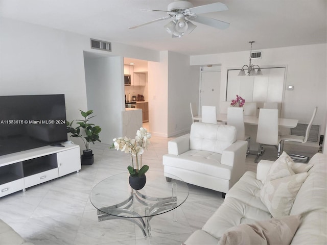 living room with ceiling fan with notable chandelier