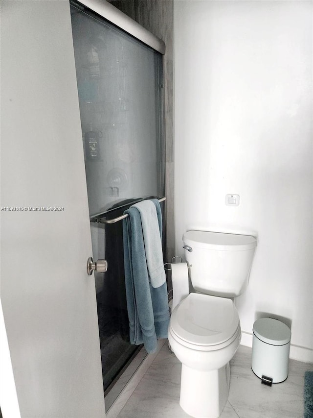 bathroom with an enclosed shower and toilet