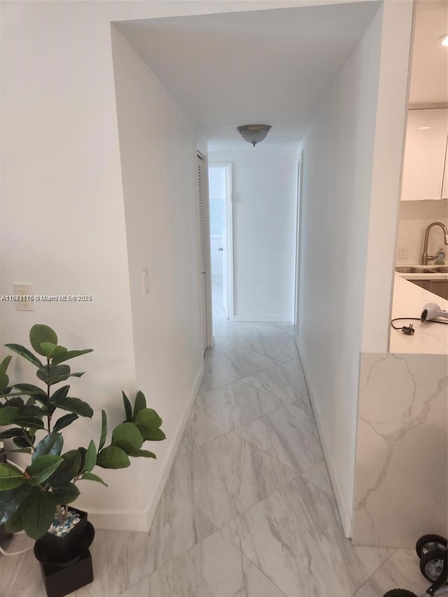 4330 Hillcrest Dr Unit 414, Hollywood, FL 33021 - hall featuring light marble finish floors, baseboards, and a sink