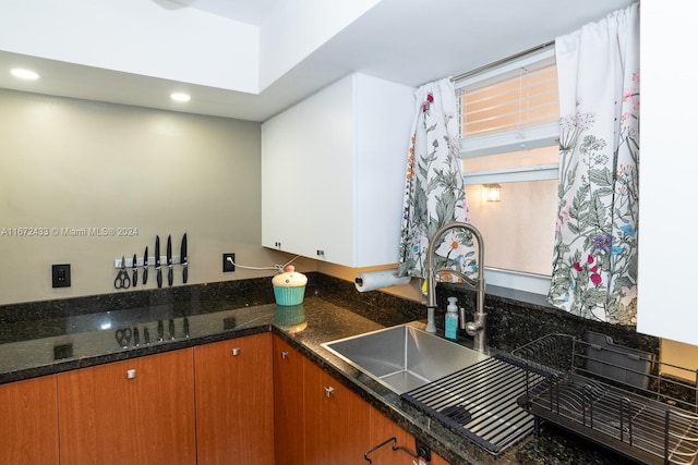 kitchen featuring dark stone countertops and sink