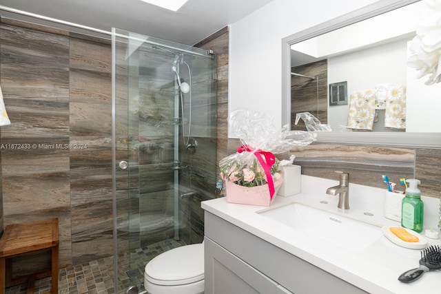 bathroom featuring vanity, toilet, and a shower with shower door