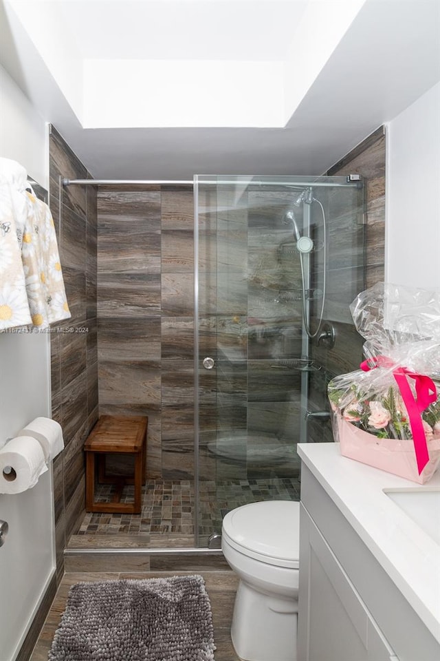 bathroom with an enclosed shower, hardwood / wood-style floors, vanity, and toilet