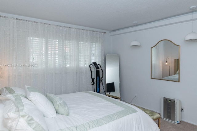 bedroom with a textured ceiling, heating unit, and carpet flooring