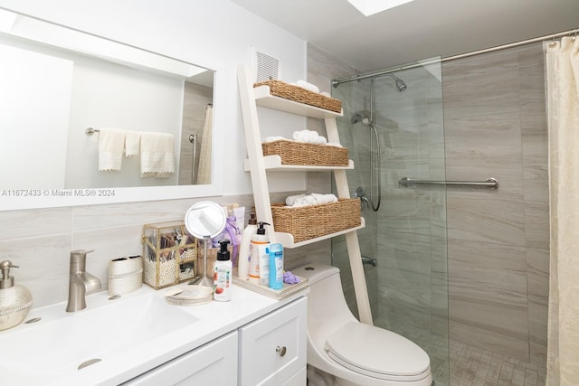 bathroom with a shower with curtain, vanity, tile walls, and toilet