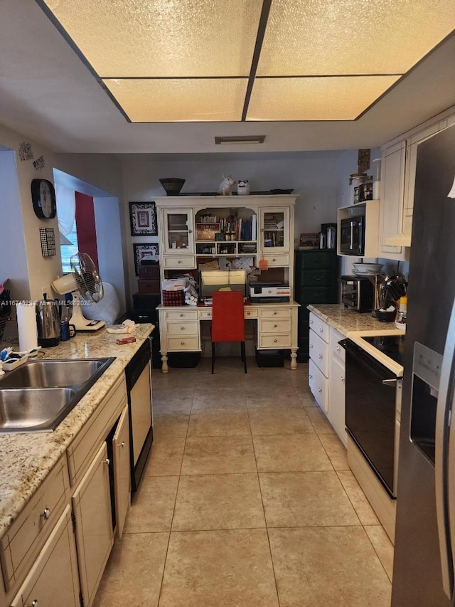 kitchen with light tile patterned floors, a sink, white cabinets, appliances with stainless steel finishes, and glass insert cabinets