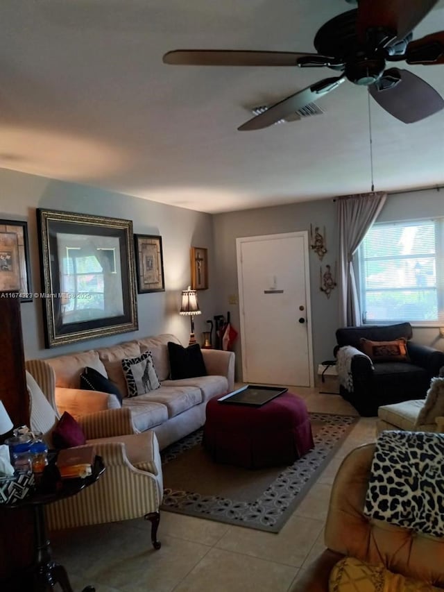 living area with ceiling fan and tile patterned flooring