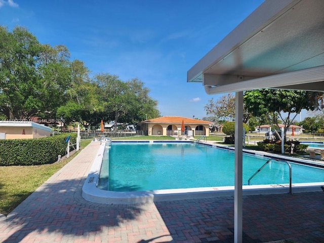 community pool with a patio and fence