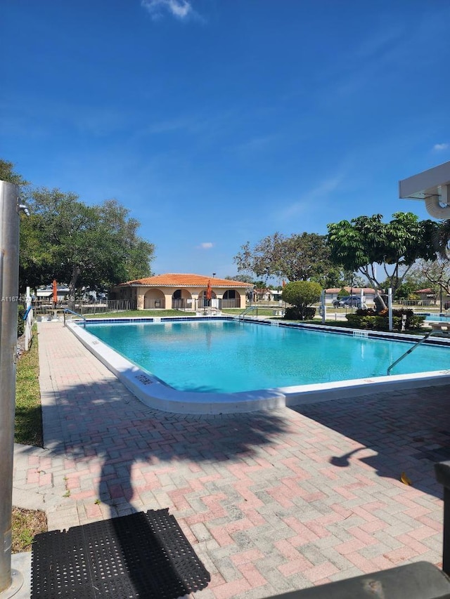community pool featuring a patio and fence