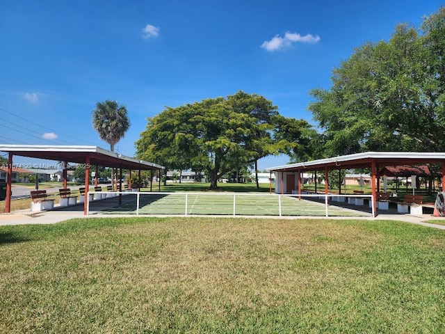 view of property's community featuring shuffleboard and a lawn