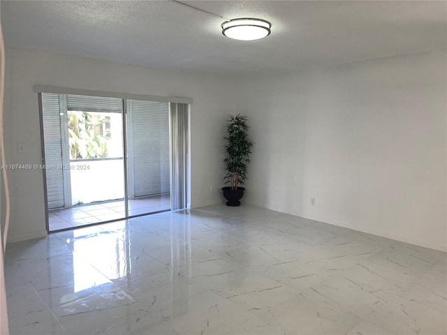 unfurnished room featuring a textured ceiling