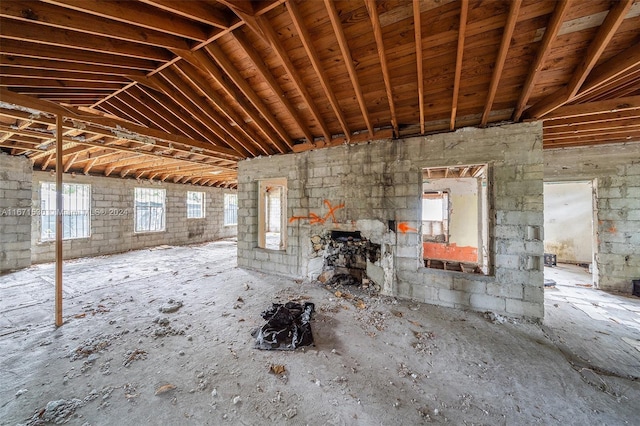 miscellaneous room featuring a fireplace and vaulted ceiling