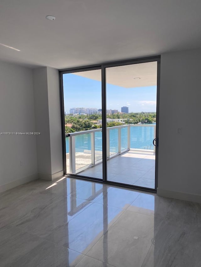 empty room featuring floor to ceiling windows and a water view