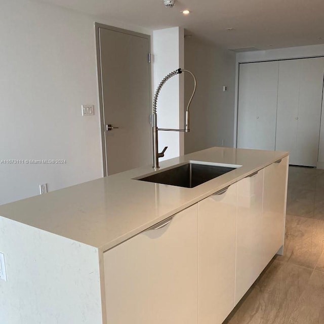 kitchen featuring sink, a center island, and white cabinets