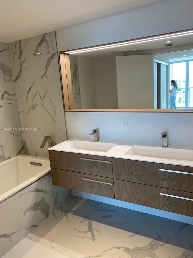 bathroom with tiled tub and vanity