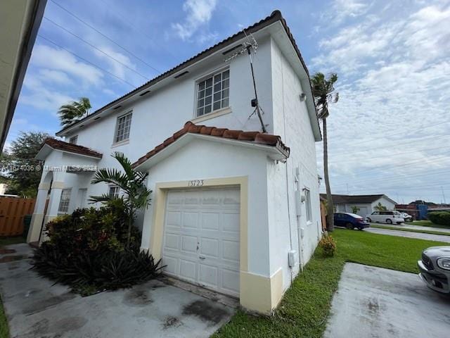 view of side of property featuring a garage and a yard