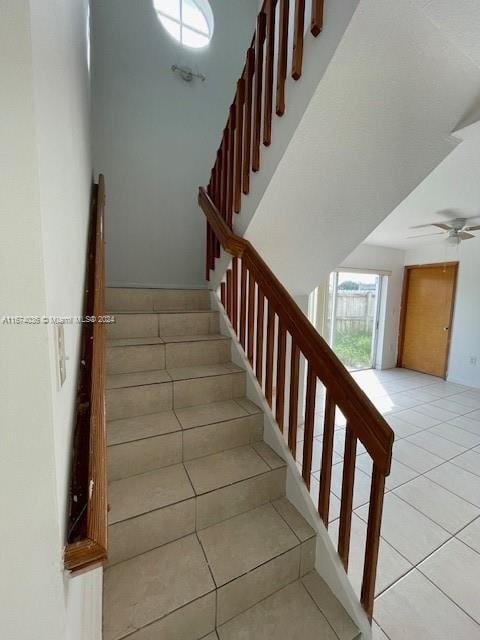 stairway featuring tile patterned floors and ceiling fan