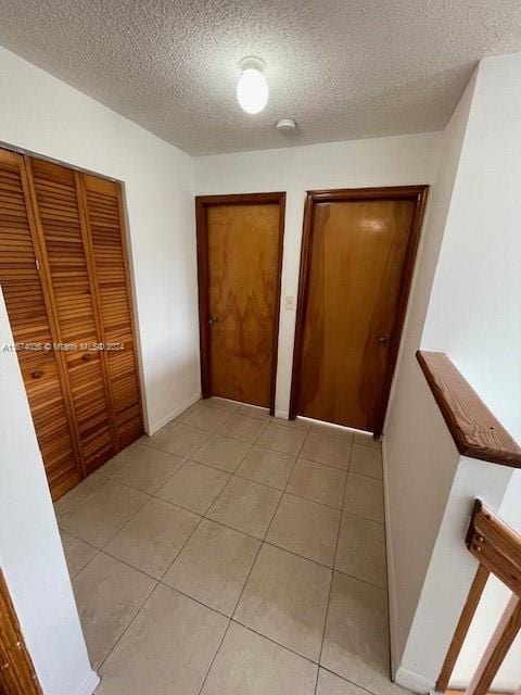 unfurnished bedroom with light tile patterned floors and a textured ceiling