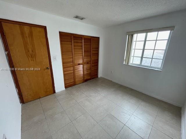 unfurnished bedroom with a textured ceiling